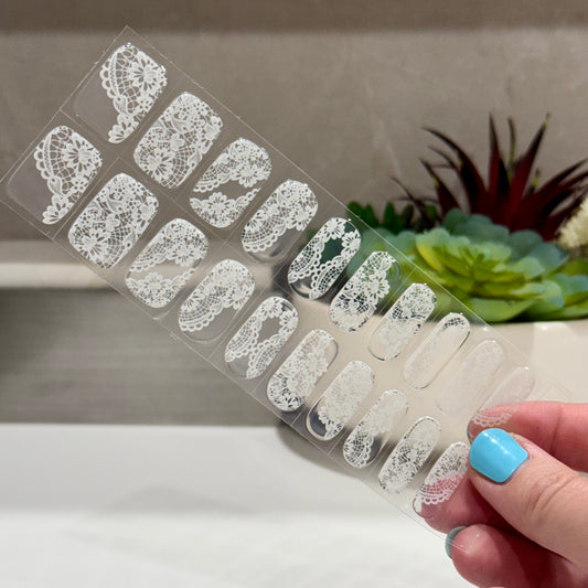 semicured gel nails with white Chantilly lace pattern on a clear background